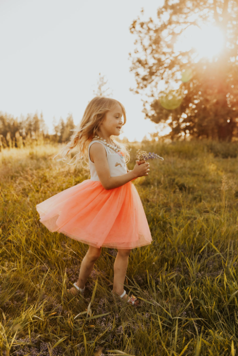 Eliza twirling in a sunlit field